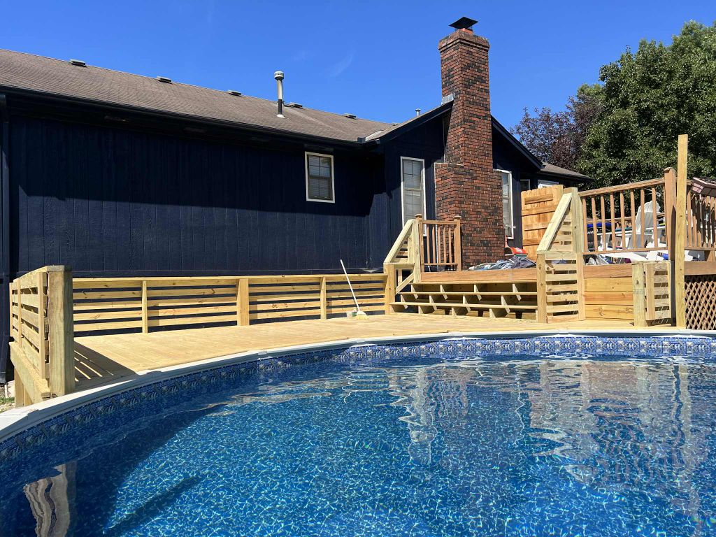 Custom poolside deck with horizontal slat railing in Kansas City backyard
